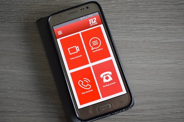Nuotrauka su telefono ekranu, kur atverta 112 programėlė. Čia keturi segmentai: vaizdo skambutis, susirašinėjimas, balso skambutis, naudingi numeriai. 