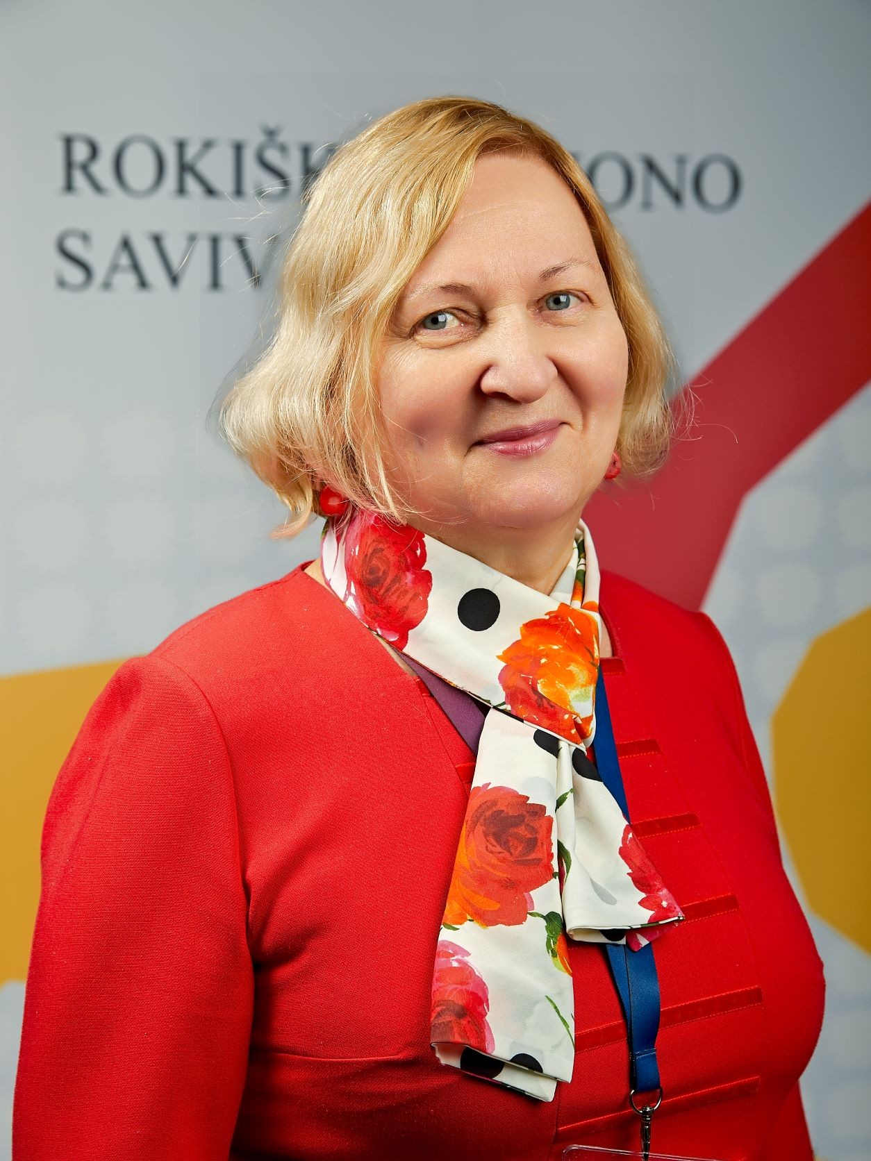 Zita Čaplikienė negalios koordinatorė, šviesių trumpų plaukų besišypsanti moteris su raudonu ir gelėta skarele ant kaklo